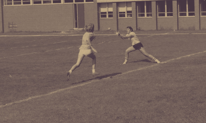 Photograph of two students running and throwing a ball