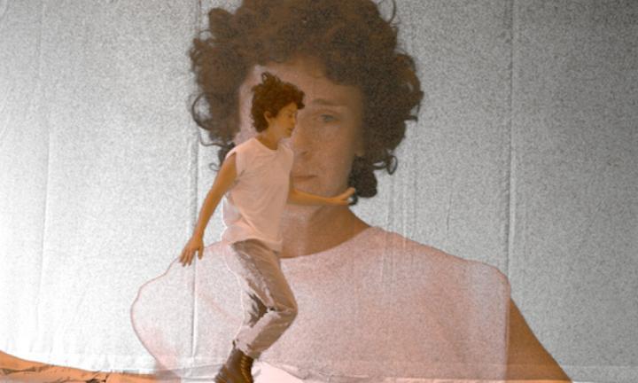 Person dancing in front of a large projection of themself