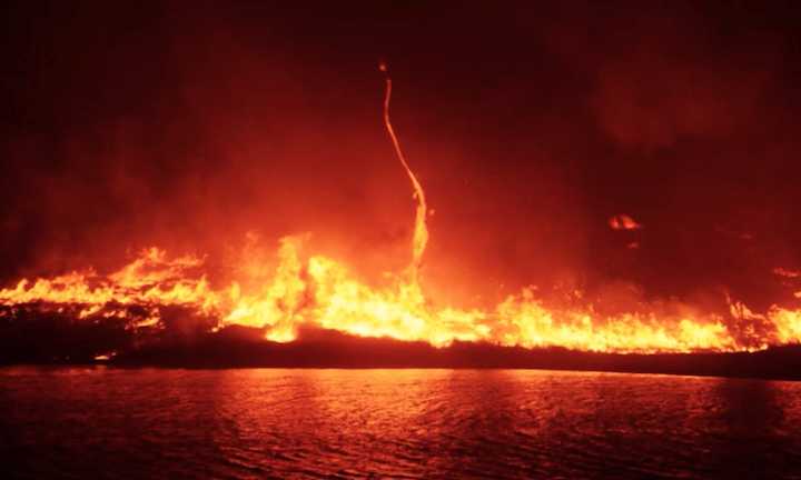 widespread flames arcing up over water
