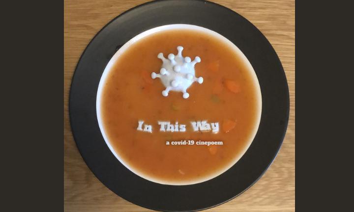 A white enlarged COVID germ in a bowl of vegetable soup with letters spelling out "In This Way"