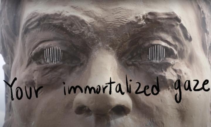 face of a statue of Simon Fraser with white lines drawn over his eyes and the words "your immortalized gaze" below