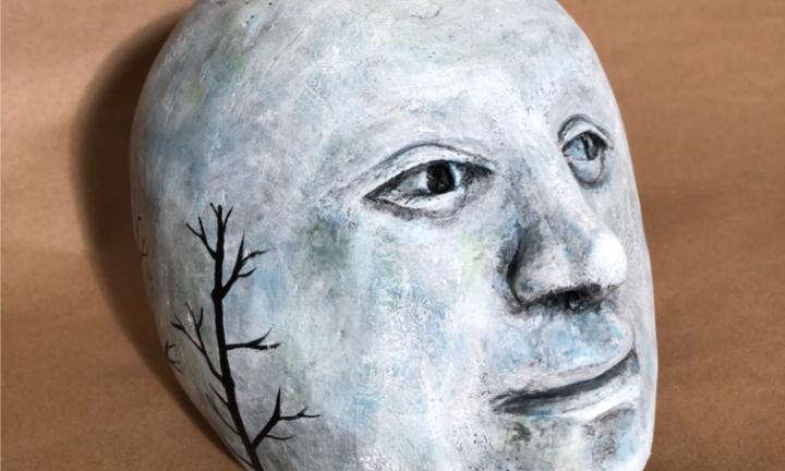 White/blue ceramic face with a silhouette of a tree on the side