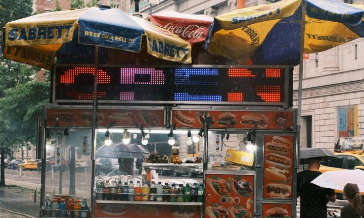 hot dog car on a rainy street with Open sign