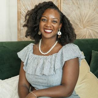 Photo of author facing camera with arms crossed, sitting on a green couch.