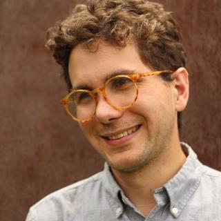 Portrait of author with orange turtleshell glasses 