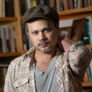 author posing in front of bookshelves