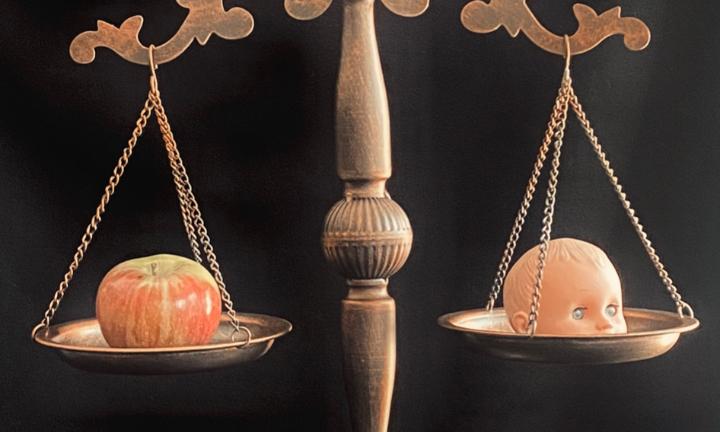 apple and doll head on scales
