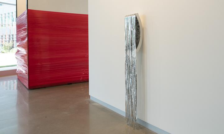 red plastic wrap around walls and silver tinsel hanging to the floor Jason S. Yi exhibit at ALL